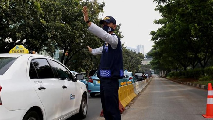 Petugas berjaga di jalur bus transjakarta di Jalan Jenderal Sudirman, Jakarta Pusat, Senin (13/6/2016). Pemprov DKI Jakarta telah mencanangkan akan menilang dan mendenda bagi kendaraan umum yang menerobos jalur bus transjakarta mulai hari ini. Hanya kendaraan tertentu yang boleh melintas, yakni ambulans, mobil pemadam kebakaran, dan mobil dinas berpelat RI.(KOMPAS.com / GARRY ANDREW LOTULUNG)