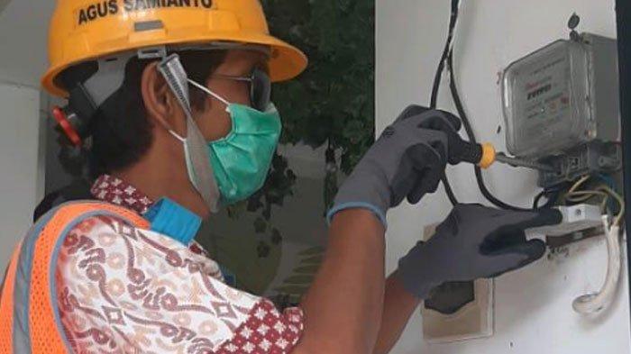 Petugas PLN saat melakukan pengecekan pada meteran listrik pelanggan.