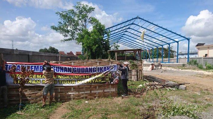 Warga Desa/Kecamatan Bandung memasang spanduk penolakan di lokasi pembangunan cold storage ikan yang ada di kampung mereka