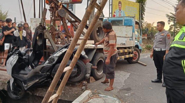 Sepeda motor korban yang masuk selokan usai terjerat kabel wifi, dievakuasi dengan bantuan katrol dari mobil derek