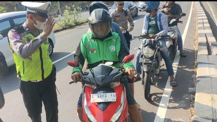 Puluhan pengendara sepeda motor dari arah Surabaya terjaring razia personel Satlantas Polres Bangkalan di pintu keluar Jembatan Suramadu sisi Madura, Selasa (14/11/2023). Polisi memberikan tindakan tegas berupa sanksi tilang karena para pemotor itu masuk di jalur roda empat yang bukan peruntukannya.