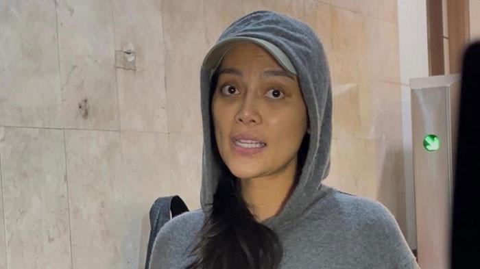 JALANI PEMERIKSAAN - Pemain film, Erika Carlina saat ditemui di Polda Metro Jaya, Jakarta, Kamis (24/7/2025) malam. Wajah Erika tampak Lelah hingga kantong mata menghitam.