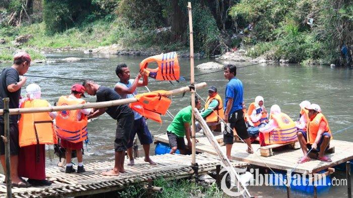 Sejumlah siswa dan warga menyeberang aliran Sungai Brantas menggunakan perahu rakit atau getek di Kelurahan Mergosono, Kota Malang, Jawa Timur, Selasa (3/10/2023). Warga dengan swadaya membuat perahu rakit karena Jembatan Lembayung diperbaiki.