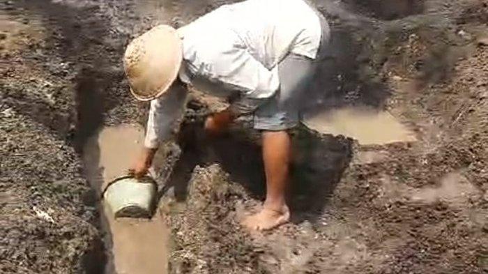Warga saat mencoba menguras air yang keluar dari lahan kering di Gunungkidul, Senin (7/10/2024)