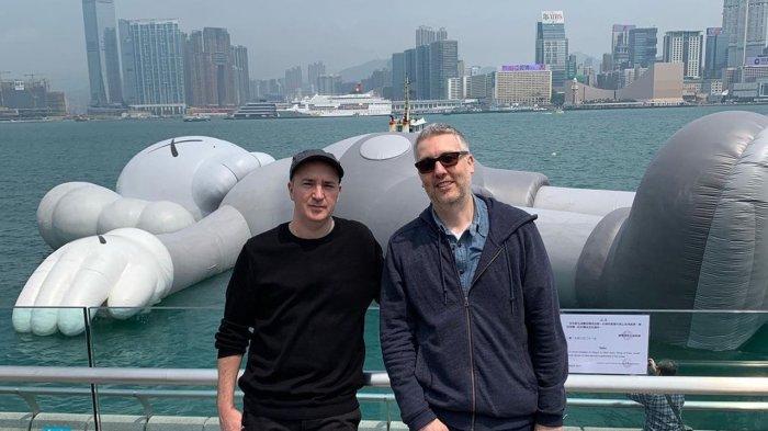 Brian Donnelly (kiri) berfoto dengan karya seninya KAWS (belakang) saat berada di Hongkong 2019 lalu.