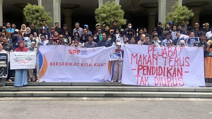 SPANDUK TUKIN - Sejumlah dosen ASN yang tergabung dalam SPF UGM dan ADAKSI membentangkan poster mendesak pemerintah mencairkan tunjangan kinerja (tukin) di Balairung UGM, Rabu (12/2/2025)