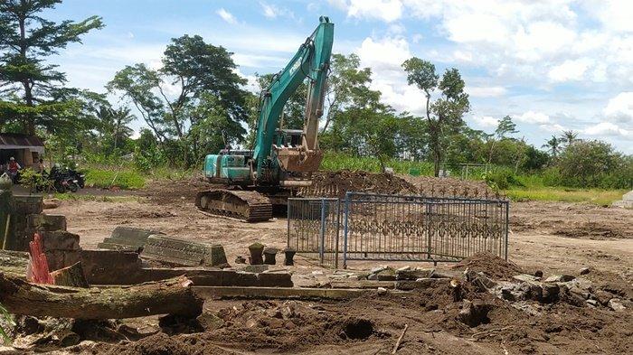 Excavator bekerja di seputar komplek makam Kyai Kromo Ijoyo yang terdampak jalan tol Jogja-Solo paket 2.2 di Kalurahan Tirtoadi, Kabupaten Sleman
