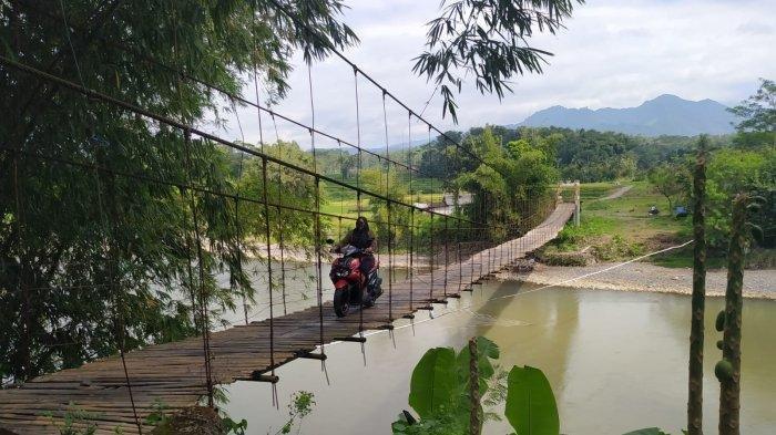 Pengendara motor melintas di atas Jembatan Gantung Ngembik pada Senin (6/5/2024). Jembatan itu kini sudah dibangun dan diberi nama Jembatan Kali Progo Sucipto Suwigo