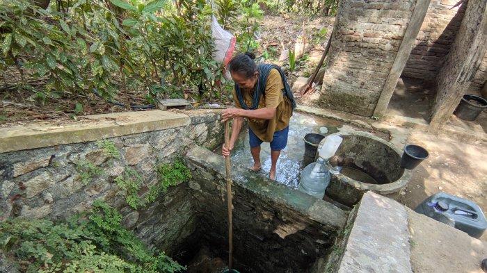 Marsinem, warga Padukuhan Sangon I, Kalurahan Kalirejo, Kapanewon Kokap, Kulon Progo saat mengambil air dari sumur yang mengering pada Kamis (17/10/2024)