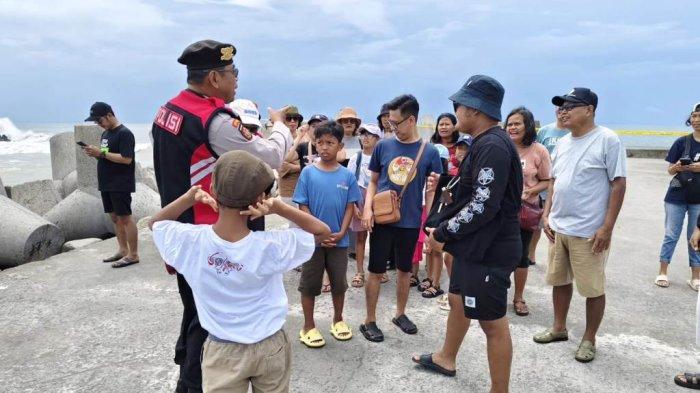 Petugas kepolisian memberikan imbauan ke wisatawan yang sedang berkunjung ke Pantai Glagah di Kapanewon Temon, Kulon Progo, Rabu (01/01/2025).