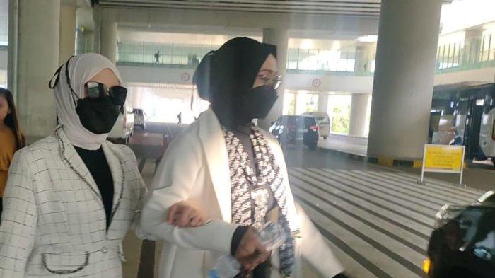 Putri Ariani (kiri) tiba di Bandara YIA, Minggu (11/6/2023) sekira pukul 07.00 WIB. Putri digandeng ibunya ke mobil menuju SMM Yogyakarta.