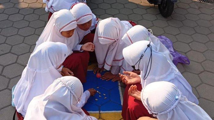BEKEL - Murid-murid SD Muhammadiyah Mantaran bermain bola bekel dalam rangka Hari Anak Nasional, Senin (24/7/2023).
