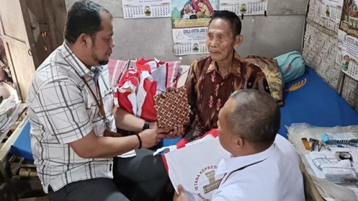 Mbah Sarno saat menerima bantuan dari Presiden Joko Widodo lewat dua orang staf khusus kepresidenan, Senin (5/8/2024)
