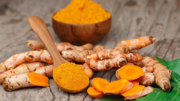 Turmeric powder in wooden bowls on wooden table