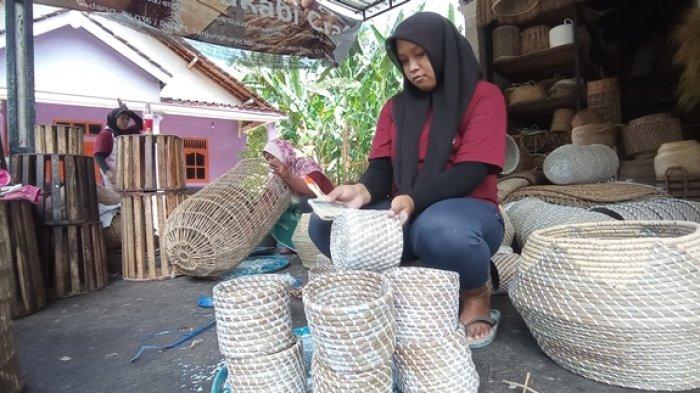 Seorang pegawai tengah mengoleskan lem di produk kerajinan yang diproduksi oleh Murakabi Craft. Pengolesan lem supaya produk kerajinan lebih kaku.