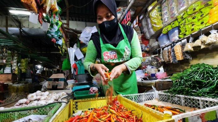 Pedagang Pasar Argosari Wonosari, Gunungkidul tengah membungkus cabai rawit merah untuk pembeli, Jumat (01/07/2022). Harga salah satu bahan pokok ini terpantau masih stabil tinggi jelang Iduladha.