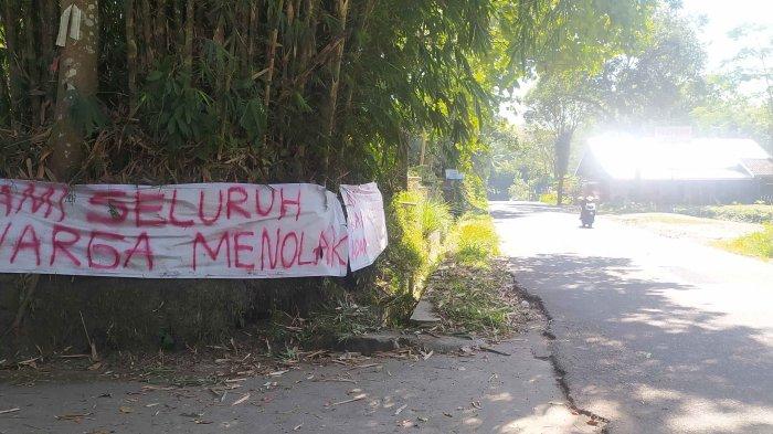 Spanduk protes menolak adanya tempat penampungan sampah sementara dipasang di akses jalan masuk menuju calon lokasi penampungan di Karenggeneng, Umbulharjo Cangkringan Kabupaten Sleman Rabu (26/7/2023)