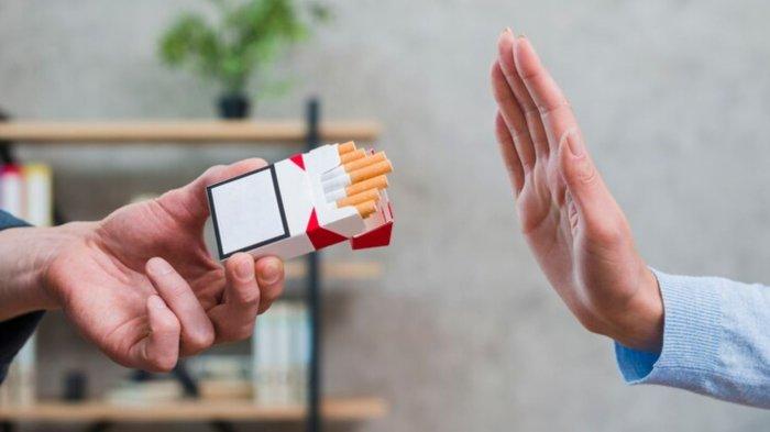Close-up of woman refusing cigarettes offered by her colleague