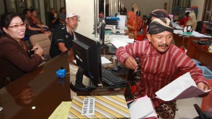 BUSANA ADAT - Para Pegawai Negeri Sipil (PNS) Dinas Perizinan Kota Yogya melayani masyarakat dengan mengenakan busana adat Jawa di kantor Balaikota Yogyakarta, Kamis (07/05). Menurut Peraturan Walikota (Perwal) tentang pakaian dinas adat, seluruh PNS di lingkungan Pemkot Yogya wajib mengenakan busana Jawa setiap selapan hari atau 35 hari sekali pada Kamis Pahing.