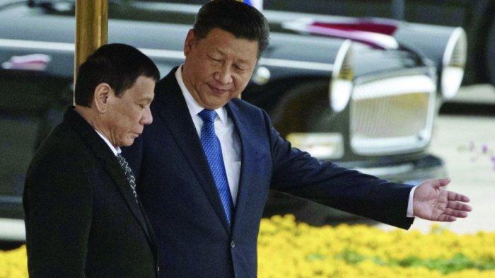 Presiden China Xi Jinping menunjukkan jalan ke Presiden Filipina Rodrigo Duterte dalam sebuah file foto.