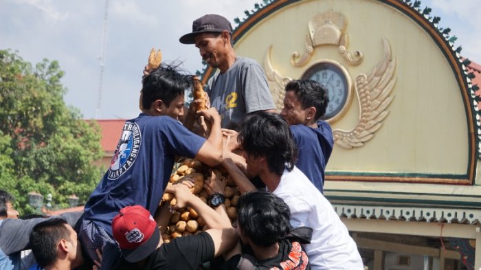 Ratusan warga saling berjibaku merayah gunungan dalam prosesi Grebeg Syawal, di Halaman Masjid Gedhe Kauman, Yogyakarta, Senin (26/6/2017).