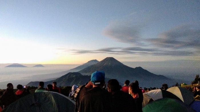 Puncak Sindoro-Sumbing (tengah) dan Merapi-Merbabu (kiri) terlihat saat matahari terbit di puncak Gunung Prau, Dieng, Wonosobo, Jawa Tengah.