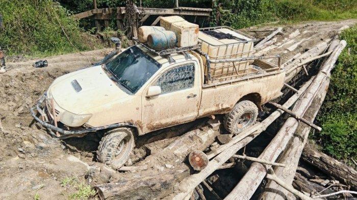 ANGKUT PASOKAN BBM - Mobil yang mengangkut pasokan BBM menuju Krayan Selatan, Kabupaten Nunukan melewati jembatan yang rusak. Foto diambil pada 7 Juni 2025.
(HO/ Rendra).