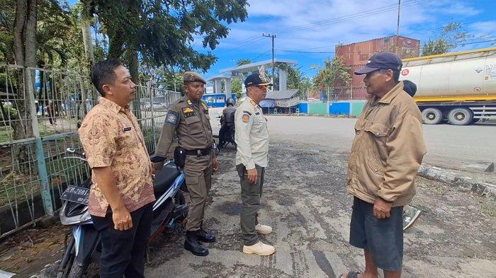 SATPOL BERI TEGURAN PKL - Tampak pihak Satpol PP Tarakan dan kelurahan memberikan arahan kepada Bapak Kusnan (memakai topi hitam dan jaket) untuk pindah lokasi ke dalam Taman Oval Lingkas Ujung, Tarakan Kalimantan Utara.