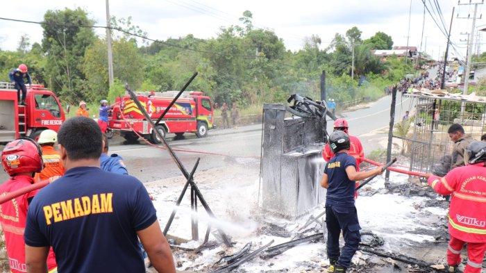 PETUGAS PADAMKAN API – Terlihat petugas PMK Bulungan menggunakan air sabun untuk memadamkan sisa-sisa api yang sesekali menyala di kios POM Mini dan LPG yang hangus terbakar di Bulungan Kalimantan Utara, Kamis (12/6/2025)