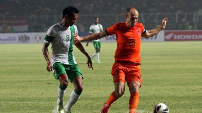 TEMUI PATRICK KLUIVERT - Pemain Tim Nasional Belanda, Arjen Robben (kanan) mencoba melewati adangan pemain belakang Timnas Indonesia, Zulkifli Syukur dalam pertandingan yang digelar di Stadion Utama Gelora Bung Karno (SUGBK), Senayan, Jakarta, Jumat (7/6/2013). Inilah profil Zulkifli Syukur, eks pesepakbola Tanah Air yang mengunggah foto di Instagram pribadinya @zulkifli_03_syukur yang perlihatkan pertemuan dengan pelatih Timnas Indonesia Patrick Kluivert.