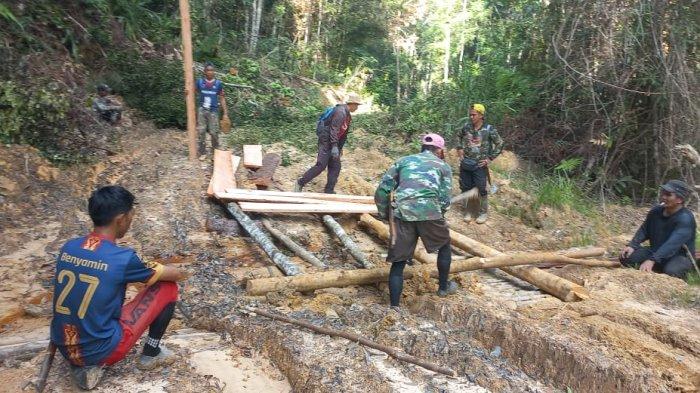 PERBAIKAN PASCA BENCANA - Warga Krayan di Kabupaten Nunukan, Kalimantan Utara (Kaltara) pikul kayu dari hutan untuk perbaikan jembatan yang rusak akibat banjir dan longsor, Minggu (08/06/2025), siang.