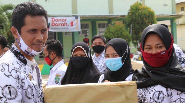 Ketua PGRI Kabupaten Nunukan, Abdul Wahid saat membagikan tali asih kepada seorang guru honorer di Sebatik Barat, Rabu (25/11/2020), pagi. (HO/ Ketua PGRI Kabupaten Nunukan).