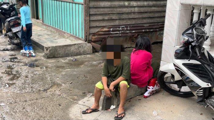 R (10) sesekali menunduk dan melihat teman seusianya bermain di depan rumahnya, Selasa (04/07/2023), sore.