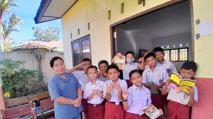 Wali Kelas 4 SDN Langkai Palangkaraya Nina bersama murid kelas IV SD, di depan ruangan perpustakaan SDN 9 Langkai Palangkaraya, Selasa (25/7/2023).