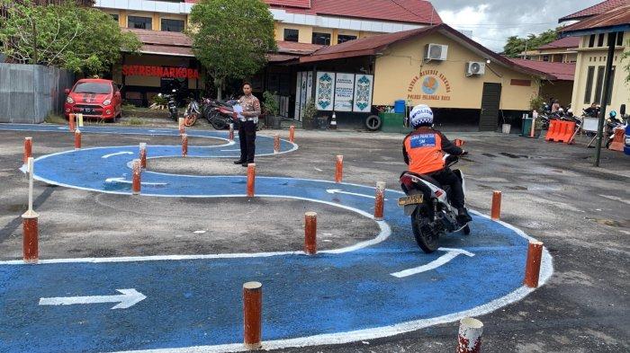 Seorang peserta uji SIM C saat melakukan tes praktek berkendara pada model ujian baru di halaman Satlantas Polresta Palangkaraya, Senin (7/8/2023).