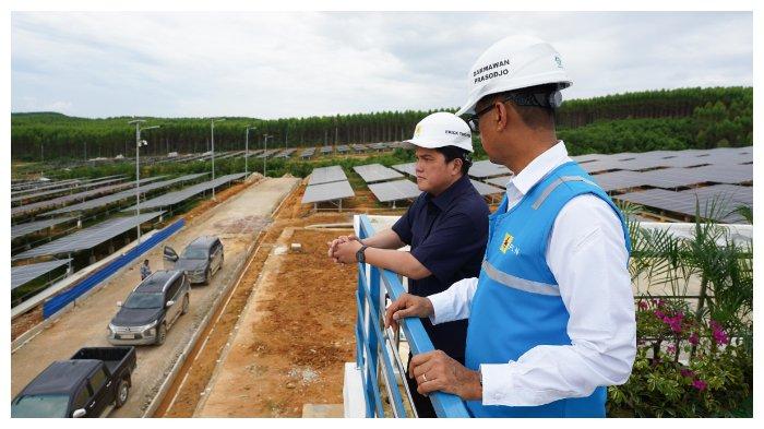 Menteri BUMN Erick Thohir (kiri) bersama Direktur Utama PLN Darmawan Prasodjo (kanan) saat meninjau pembangkit listrik tenaga surya (PLTS) Ibu Kota Nusantara, di Penajam Paser Utara, Kalimantan Timur, Sabtu (29/6/2024).