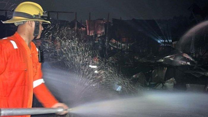 Tampak petugas saat memadamkan api yang membakar bagunan dari bahan kayu di Jalan Pantai Cemara Labat 2 Palangkaraya.