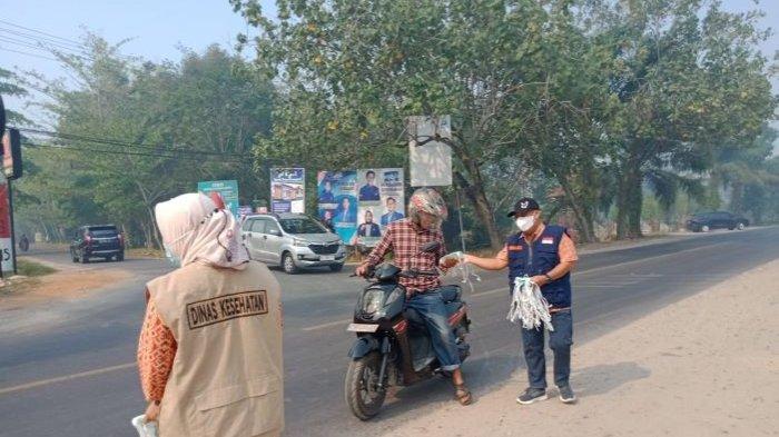 Petugas Dinkes Kotim saat membagikan masker gratis kepada pengendara di Sampit