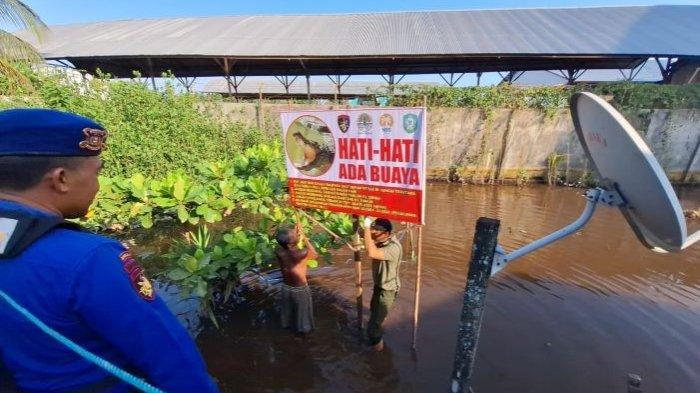Cegah serangan buaya ke manusia, Petugas BKSDA Pos Sampit memasang papan peringatan waspada serangan buaya.
