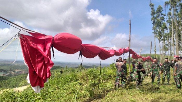Personel Kodam VI/Mulawarman mempersiapan pengibaran bendera raksasa di Glamping IKN Nusantara.