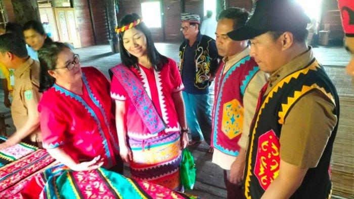 Sekretaris Dekranasda Kubar Yuyun Diah Setyorini (dua kiri) didampingi Camat Linggang Bigung (Kanan) beserta pengrajin binaan Dekranasda Kubar mendampingi tim Peniliai Pokdarwis Kaltim saat meninjau produk kerajinan Khas Kubar di Lamin Melapeh, Kampung Linggang Melapeh, Kutai Barat.TRIBUNKALTIM.CO/HO
