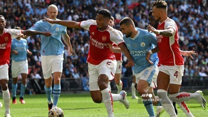 Bek Arsenal asal Prancis William Saliba (Tengah) membela diri saat gelandang Manchester City asal Kroasia Mateo Kovacic (2R) berlari ke arah gawang selama pertandingan sepak bola Community Shield FA Inggris antara Arsenal dan Manchester City di Stadion Wembley, di London, 6 Agustus 2023. Duel Bigmatch Arsenal vs Mancehseter City di Liga Inggris pekan ke-8 malam ini bisa disaksikan langsung di SCTV dan melalui live streaming Vidio.com.