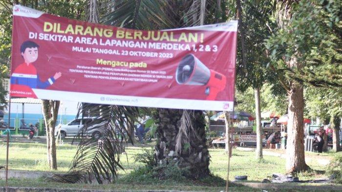 Plang berwarna merah berkelir putih, yang dipasang oleh Pertamina RU V Balikpapan berisikan larangan berjualan di sekitar area Lapangan Merdeka 1,2 dan 3 mulai 23 Oktober 2023.