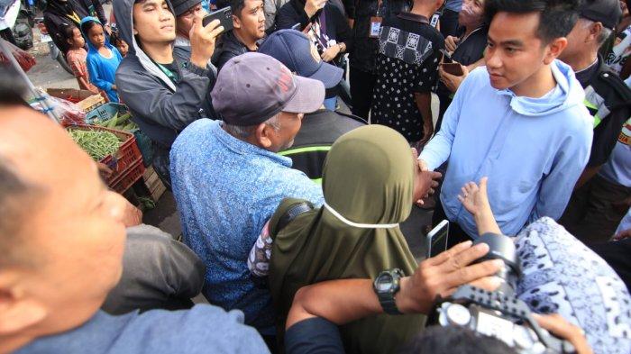 Calon Wakil Presiden Gibran Rakabuming Raka didampingi mantan Wakil Gubernur Jawa Timur, Emil Dardak beserta mantan ketua umum PSI Grace Natalie berinteraksi dengan pedagang Pasar Pandansari, Balikpapan, Sabtu (16/12/2023).