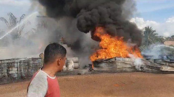 Para pemadam kebakaran tengah berupa menangani kobaran api yang melahap drum-drum berisi solar di Simpang Pasir, Palaran, Samarinda, Kalimantan Timur pada Selasa (6/2/2024).