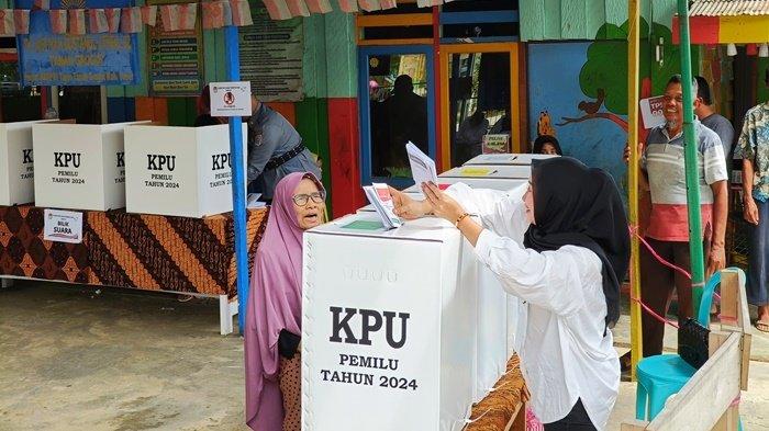 Seorang lansia dibantu oleh petugas KPPS memasukkan surat suara di kotak suara usai mencoblos di TPS 009, Desa Tapis, Kecamatan Tanah Grogot, Kabupaten Paser, Rabu (14/2/2024).