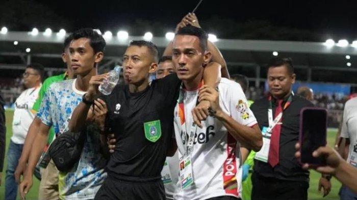 Tim medis memberikan perawatan kepada wasit Eko Agus Sugih Harto (tengah) yang dipukul bek Sulawesi Tengah, Muhamad Rizki Saputra, pada laga antara tim Aceh dan Sulawesi Tengah dalam perempat final PON Aceh-Sumut 2024 di Stadion Haji Dirmurthala, Banda Aceh, Sabtu (14/9/2024) malam