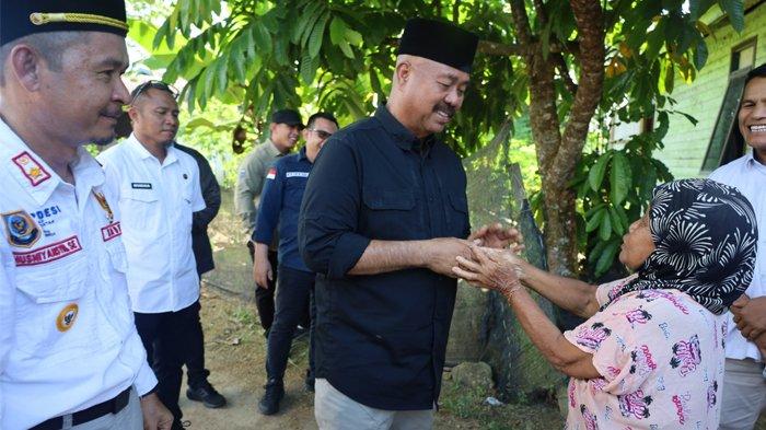 Bupati Kukar Edi Damansyah menyalami warga lansia bernama Sarinah (80) saat mengunjungi Desa Tanjung Batu, Tenggarong Seberang, Kutai Kartanegara, Kalimantan Timur.