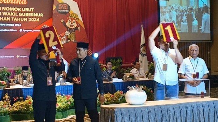 PILKADA SUMUT 2024 - Paslon Gubernur Sumut Bobby-Surya saat menunjukan nomor urut 1 dan lawannya Edy-Hasan menunjukan nomor urut 2 saat proses pengundian nomor Paslon di Pilkada Sumut 2024 di Hotel Grand Mercure, Medan Senin (23/9/2024). Pilkada Sumut 2024 sudah diwarnai saling sindir. Bobby Nasution singgung jalan rusak, Edy Rahmayadi sebut itu jalan Jokowi.