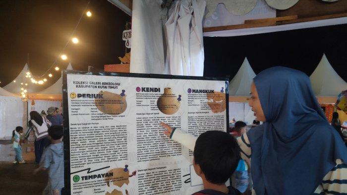 EVENT BUDAYA KUTIM - Salah satu pengunjung yang memberikan edukasi terkait Cagar Budaya pada Buah Hatinya dalam Pentas Seni Kebudayaan, Kuliner, dan Adat Nusantara di Polder Ilham Maulana, Sangatta, Kutai Timur, Provinsi Kalimantan Timur.